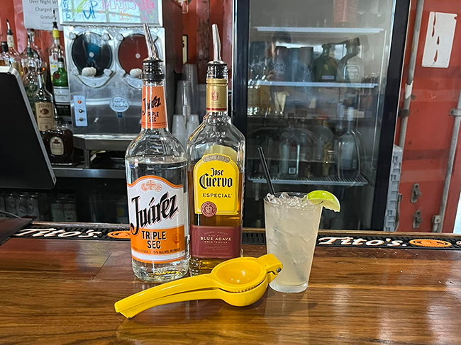 Bar top with tequila, triple sec and a margarita