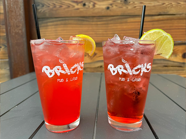 Two cocktails in Bricks pint glasses with lemons